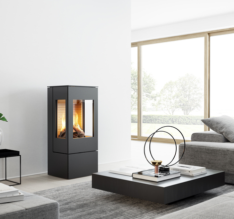 NEXO 100 GAS in Schwarz mit zwei Seitenfenstern Gas-Kaminofen NEXO 100 in Schwarz mit Stahltür und zwei Seitenfenstern in einem modernen, hellen Wohnraum