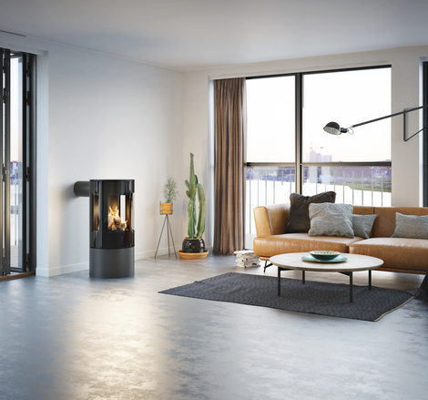 VIVA 100 L GAS in Platin mit Vollglas-Feuerraumtür Gas-Kaminofen VIVA 100 L in Platin mit Vollglas-Feuerraumtür in einer minimalistischer Wohnung mit Aussicht auf die Skyline